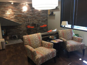 Cozy seating area with patterned armchairs and a stone fireplace.