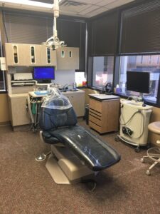 A dental office with a patient chair and dental equipment.