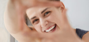 Close-up of smiling woman framing face